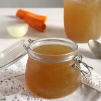 golden bone broth in a jar and a bottle