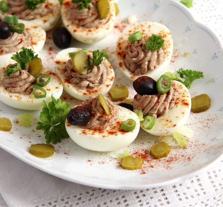 romanian deviled eggs with olives and sprinkled with paprika.