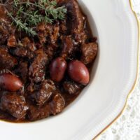 beef stew with red wine and olive on a white plate