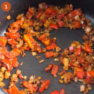 sauteing chopped red peppers and onions for jamaican rice in a skillet.