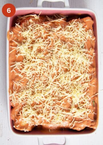 sprinkling grated cheese on an enchilada dish before baking.