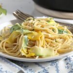 plate with yellow pasta with cream and zucchini