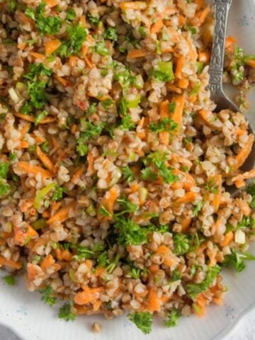 vegan buckwheat salad with grated carrots and parsley on a platter.