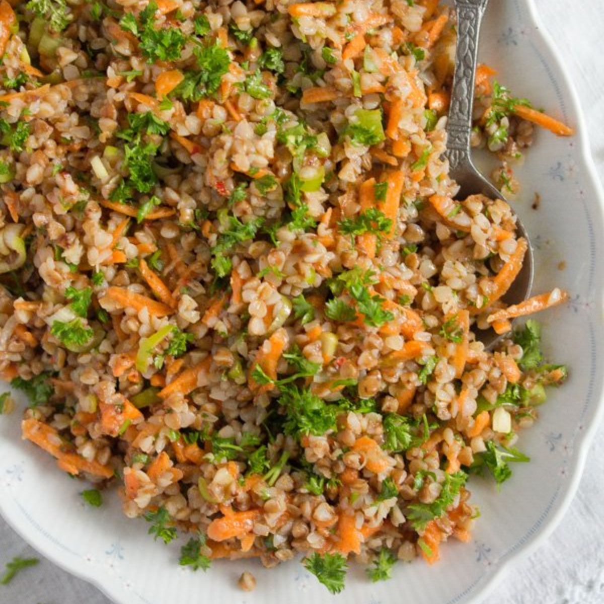 vegan buckwheat salad with grated carrots and parsley on a platter.