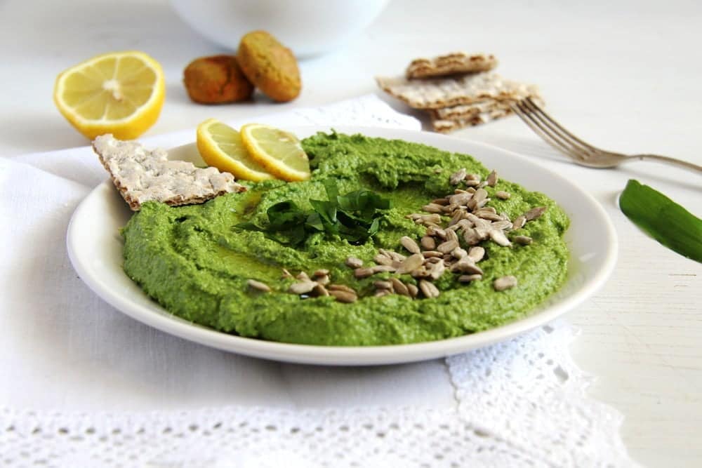 wild garlic spread with sunflower seeds and lemon on a plate