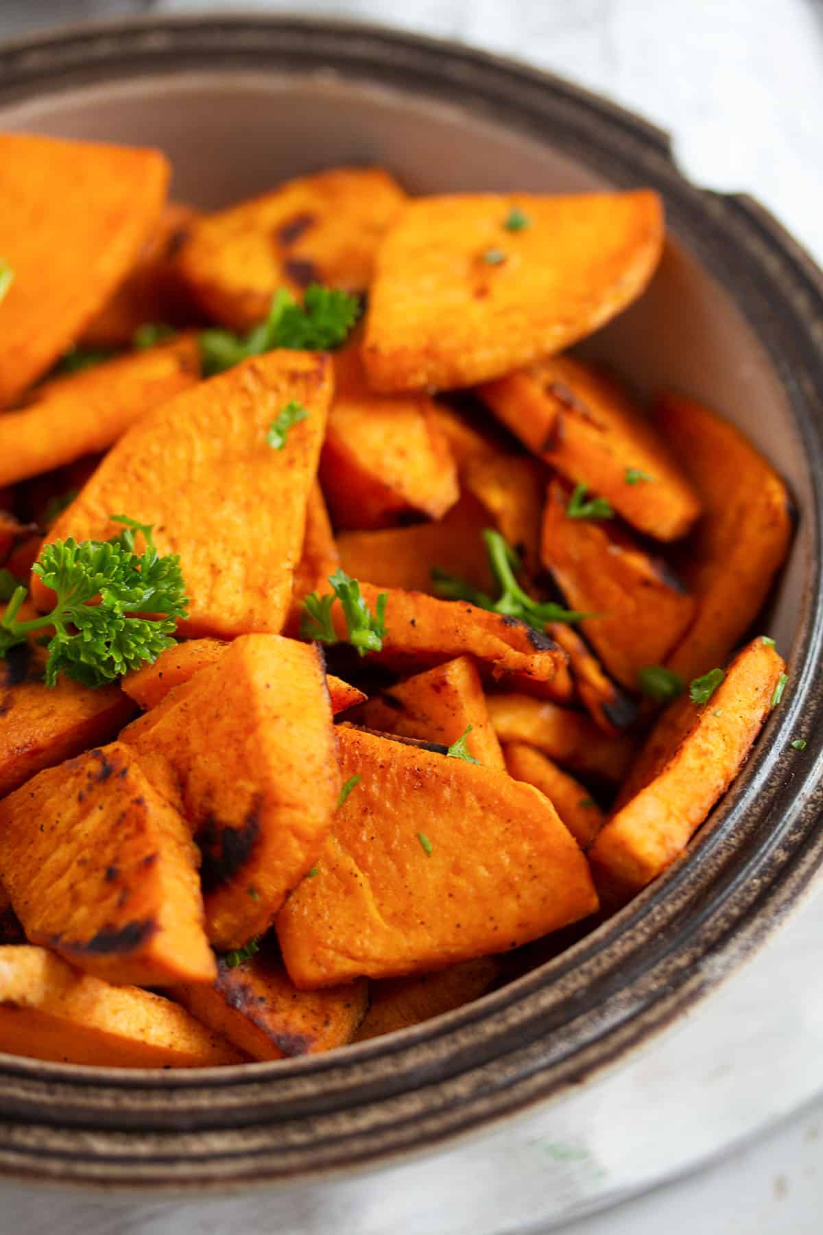 close up of pan-fried sweet potatoes in a small chipped bowl. 