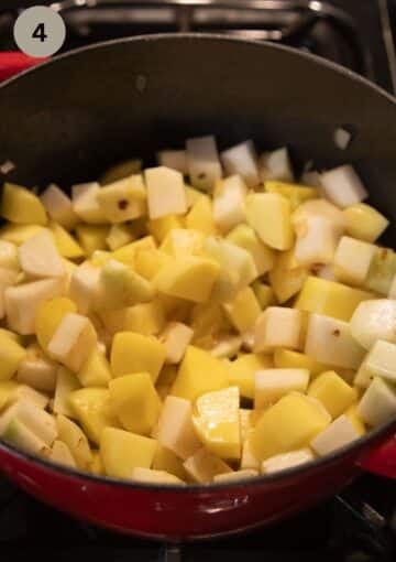 adding kohlrabi and potato cubes to a pot to make soup.