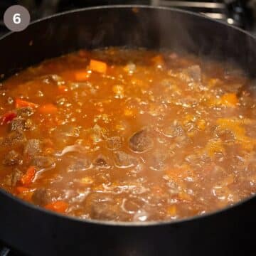beef goulash simmering in a pot.