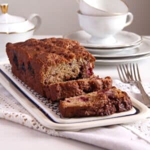 rhubarb and blackberry loaf cake sliced on a vintage platter.