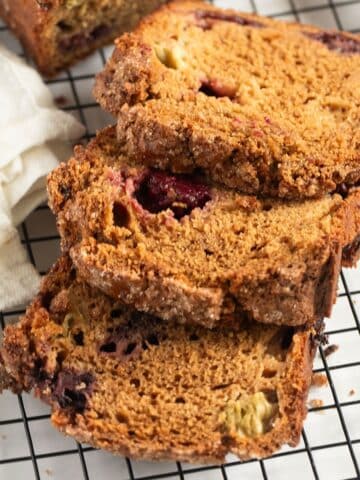 rhubarb and blackberry loaf cake sliced on a wire rack.