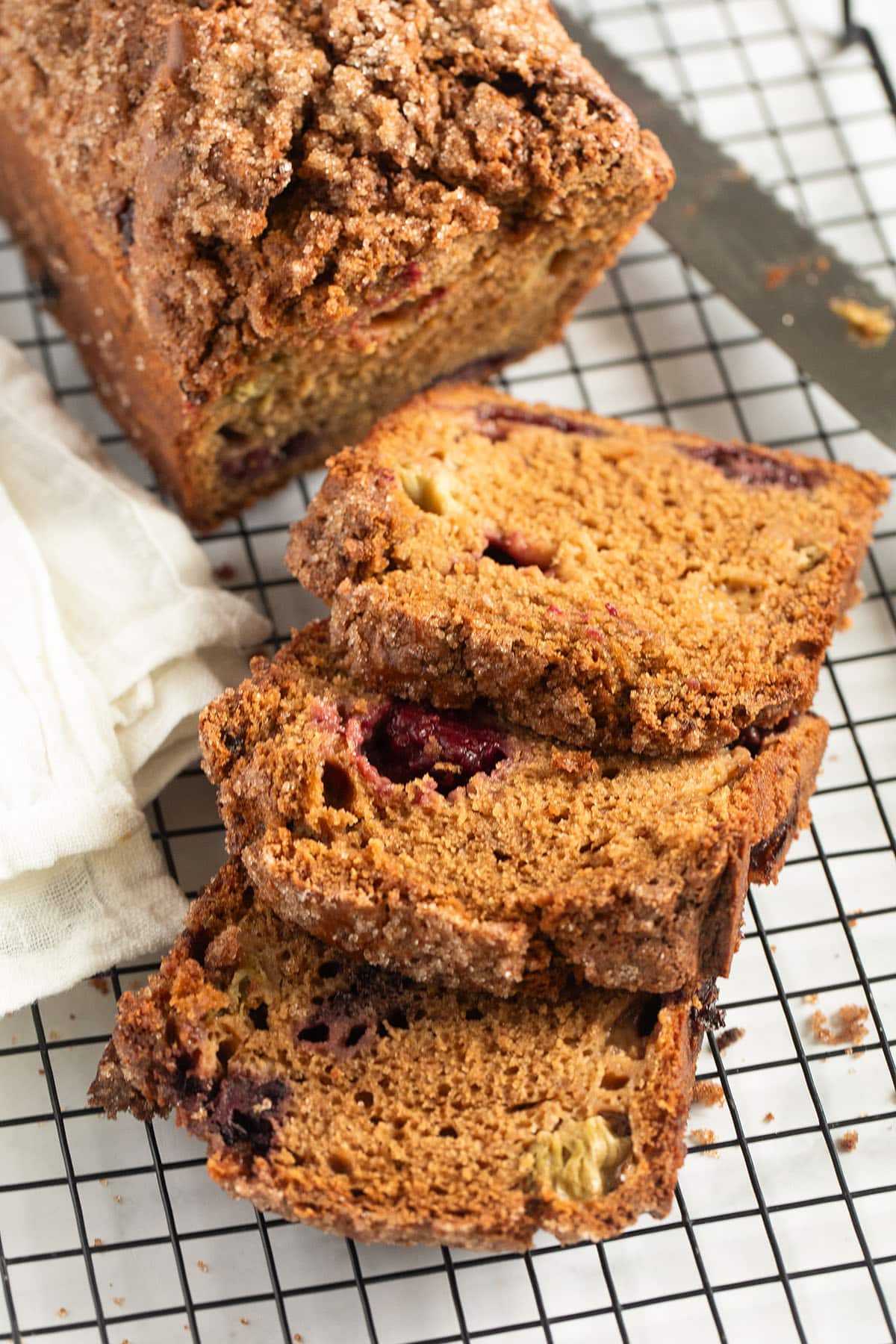 blackberry and rhubarb loaf cake on a wire rack. 
