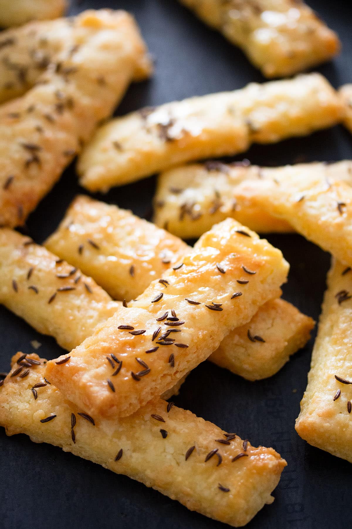 many cheese crackers sprinkled with caraway seeds.