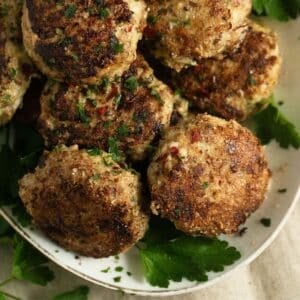 turkey meatballs no breadcrumbs and parsley leaves on a serving platter.