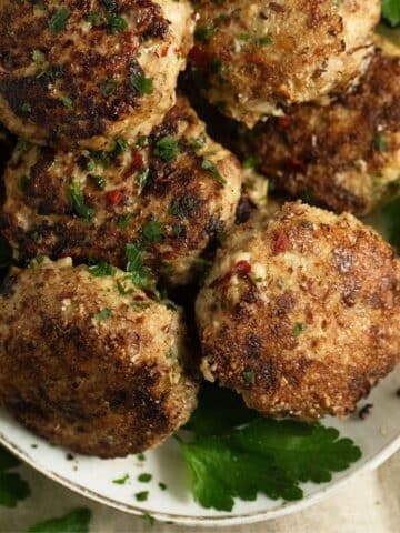 turkey meatballs no breadcrumbs and parsley leaves on a serving platter.