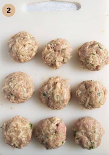 freshly shaped, raw turkey meatballs on a cutting board.