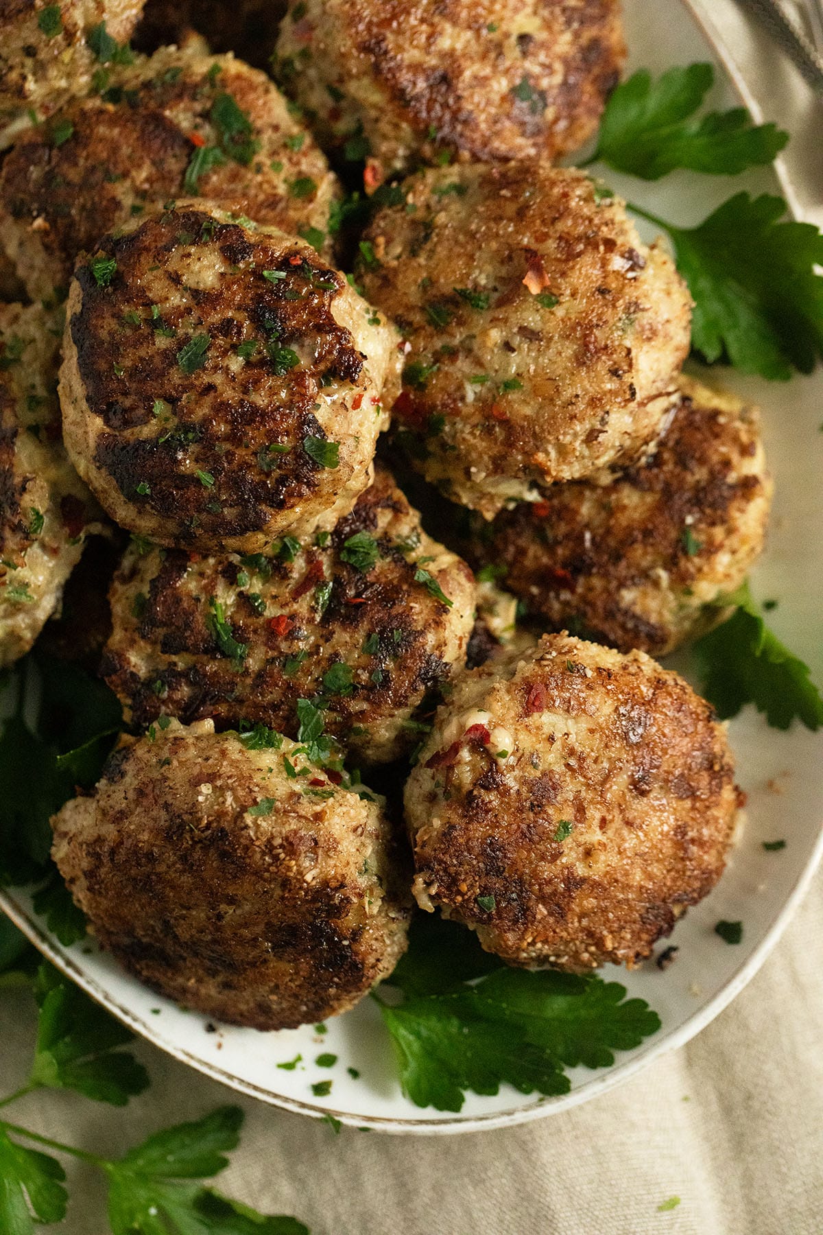 round turkey meatballs with ground almonds on a platter.