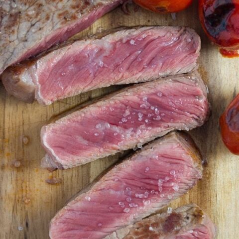 salted steak slices on a board