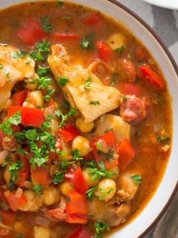 bowl of spanish chicken and chorizo stew with peppers and chickpeas