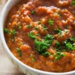 balkan ajvar dip in a rustic bowl sprinkled with parsley.