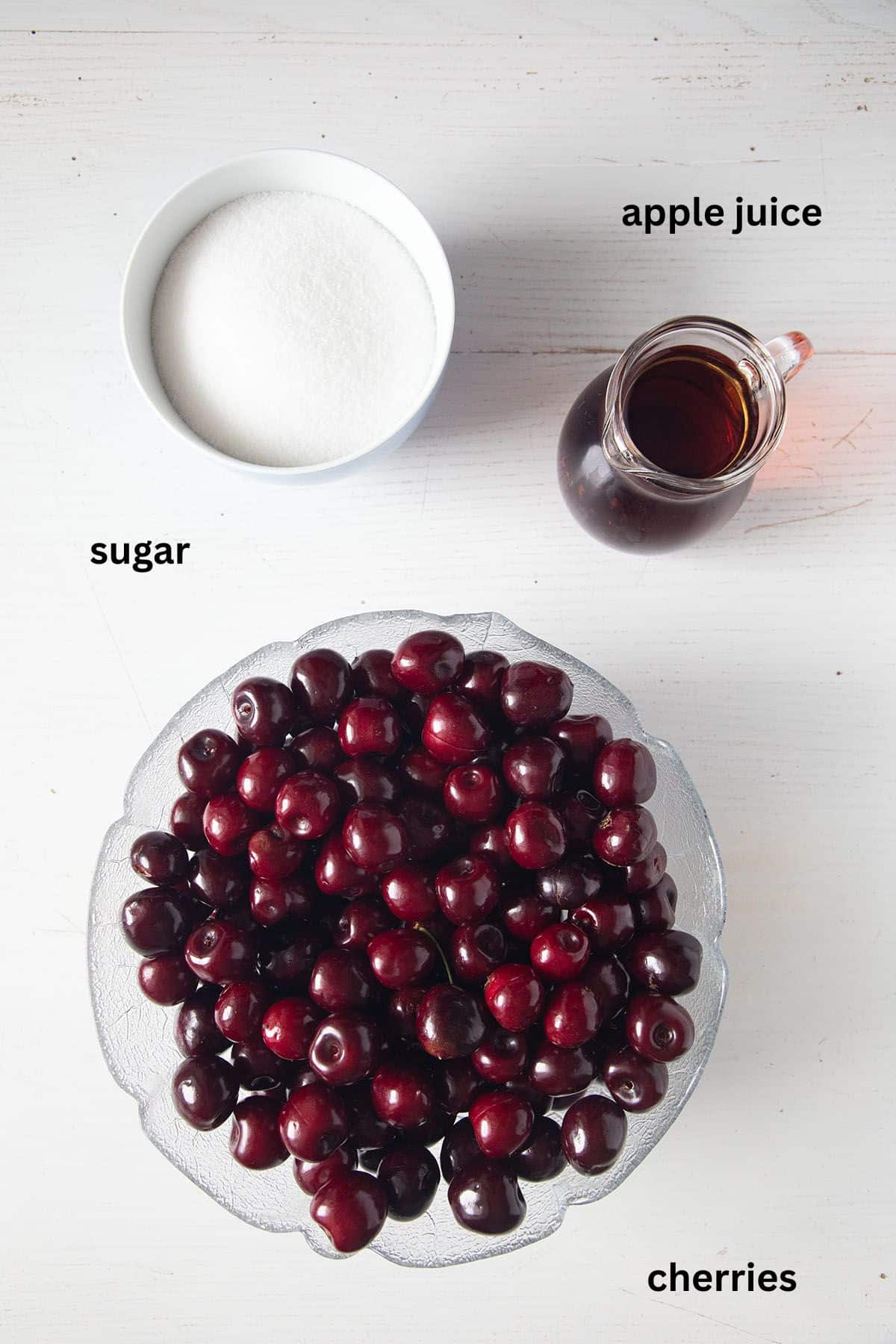 labeled ingredients for making cherry butter with fresh cherries, sugar and apple juice.