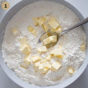 adding butter cubes to flour to make dough for scones.