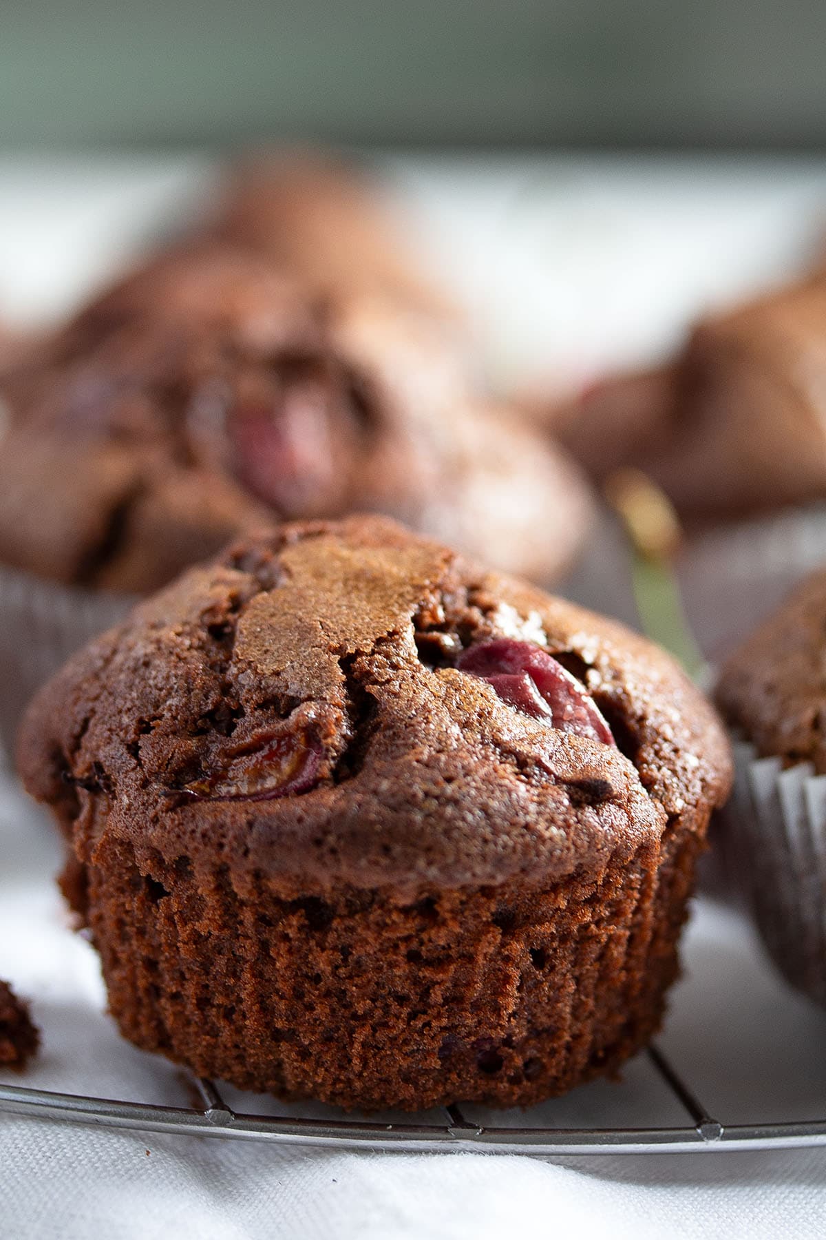 a muffin with chocolate and cherries on the table. 