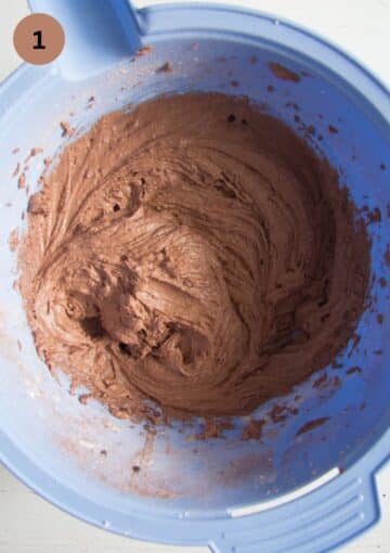 mixing butter, cocoa powder and eggs in a blue mixing bowl for making muffins.
