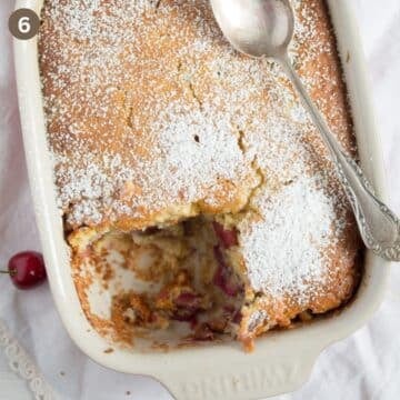 baked kirschmichel with a piece missing and a spoon in a baking dish.