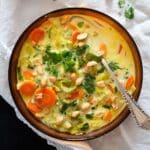 peanut soup with whole peanuts in a bowl with a spoon in it.