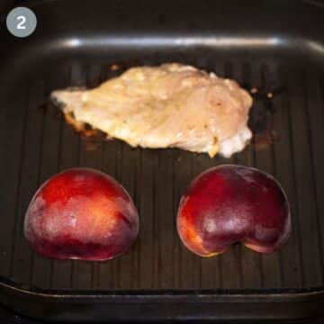 one chicken breast and two peach halves in a grill pan.