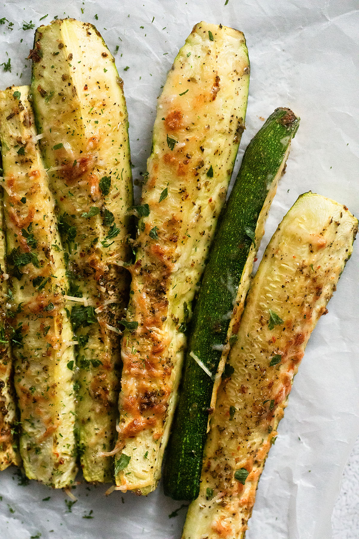 five golden brown baked zucchini wedges.
