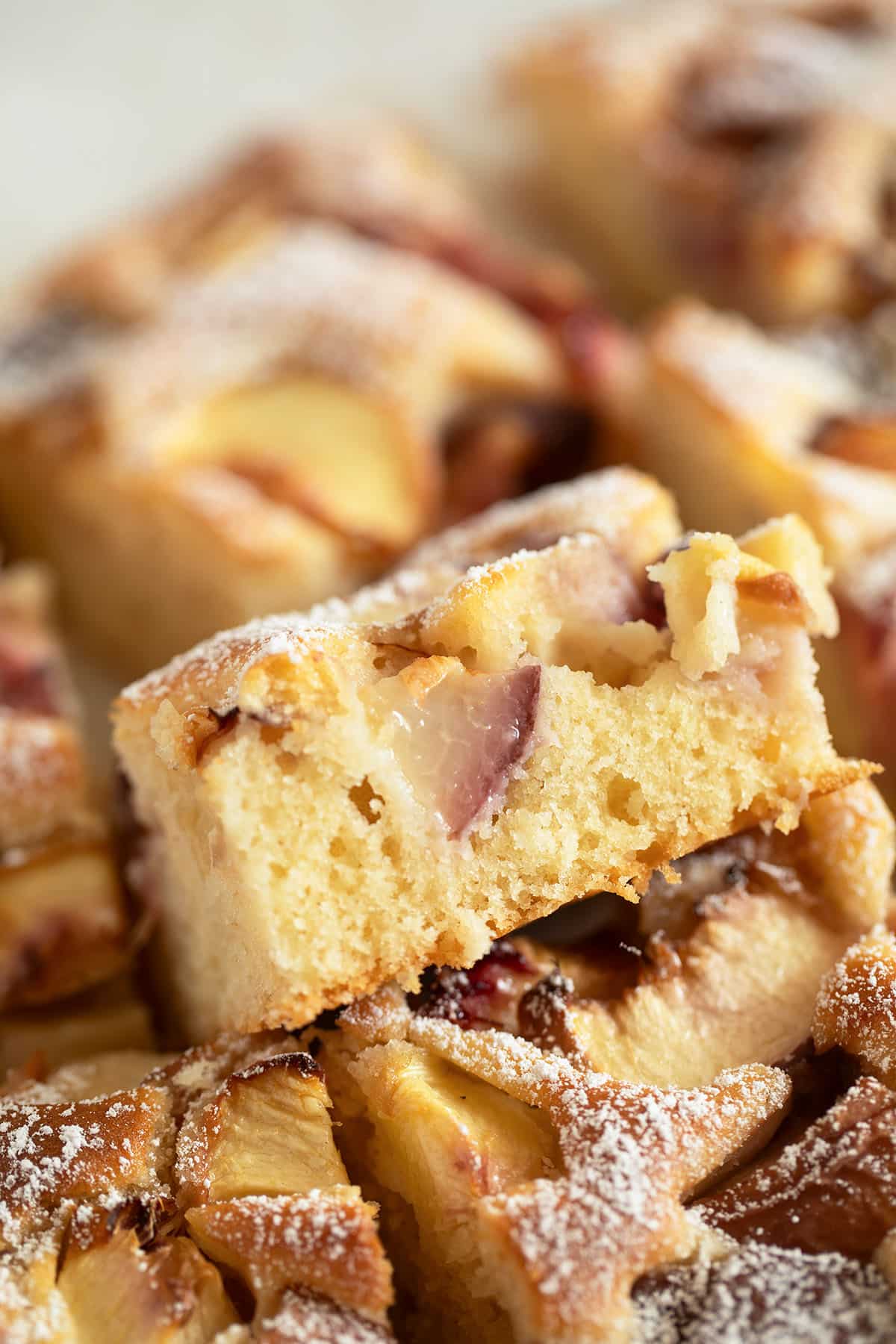 fluffy pieces of peach sour cream cake stapled on the table. 