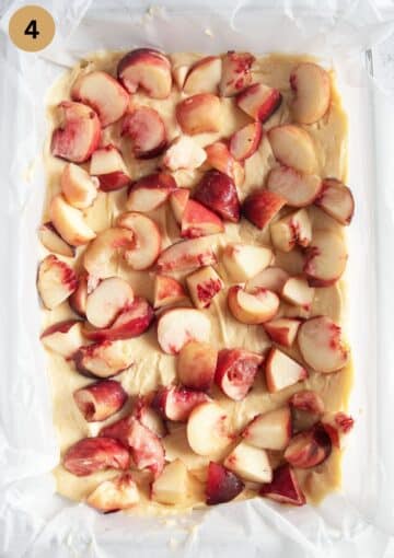 adding peach pieces to bake batter in a baking dish.