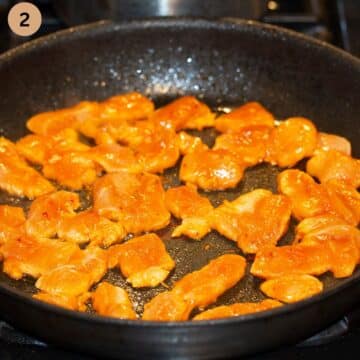 uncooked chicken pieces coated in gochujang in a pan.