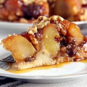 a luscious slice of apple caramel cake showing the large apple pieces and the oozing caramel on the plate.