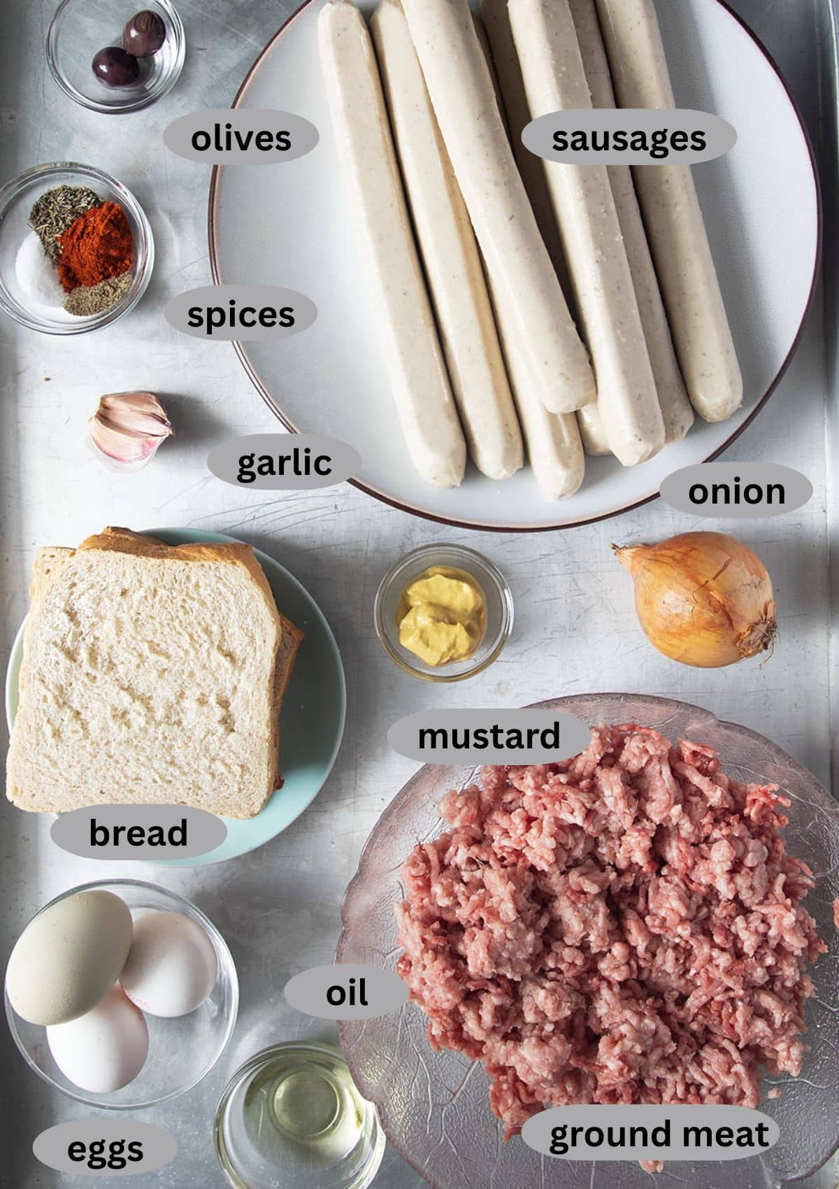 listed ingredients to make spider meatloaf with ground meat, sauages, white bread, spices, eggs, onion, garlic.