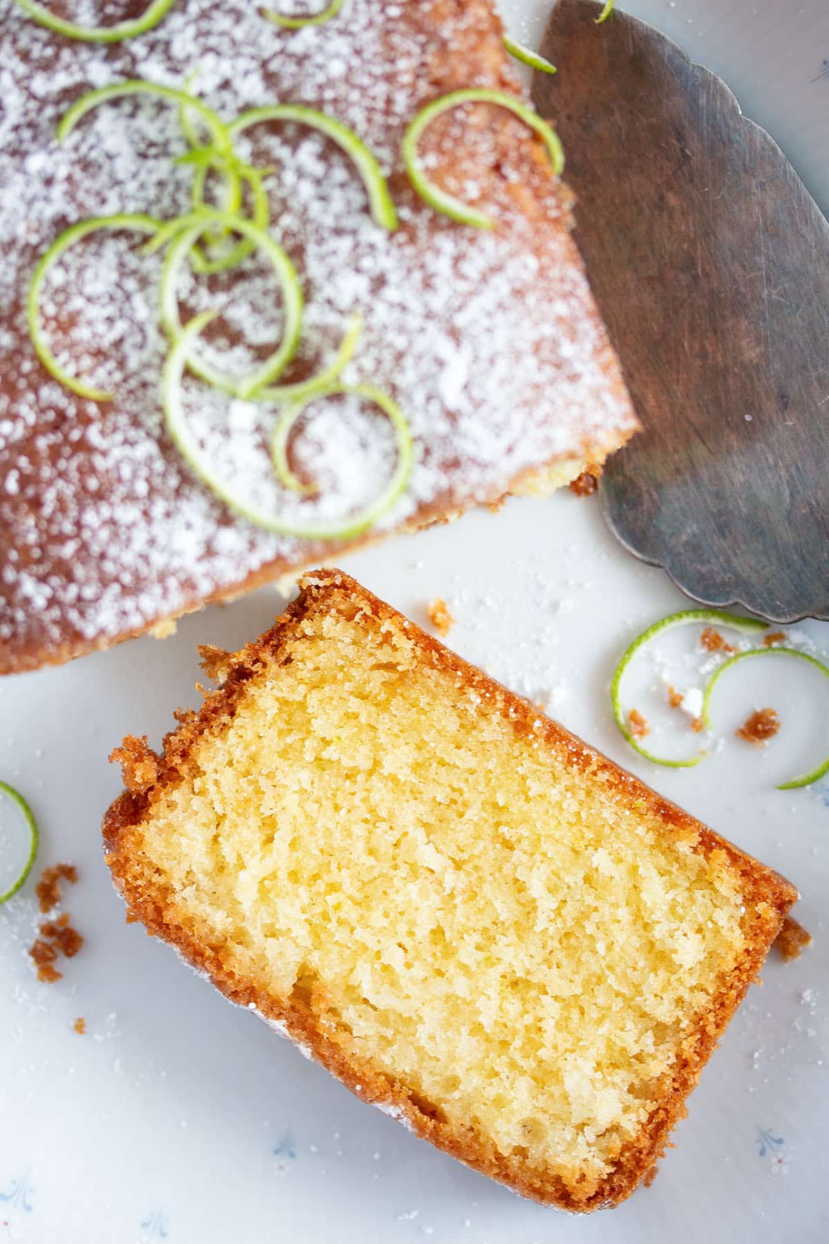 lime drizzle cake slice and the rest of the loaf beside it.