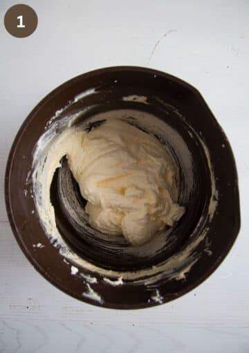 mixed butter and eggs in a brown bowl for making cake batter.