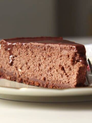 a slice of nigella lawson's chocolate cheesecake with a fork on a plate.