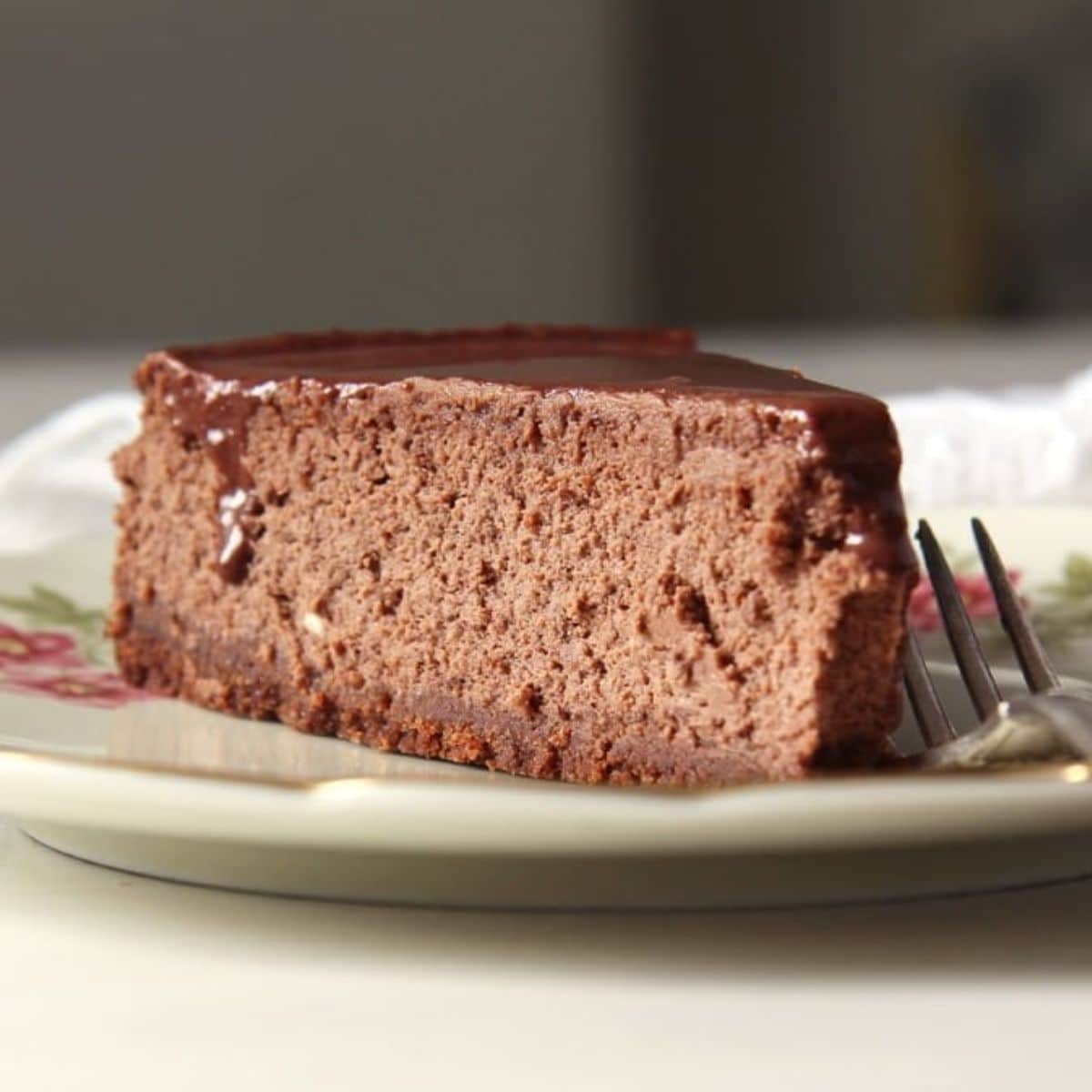 a slice of nigella lawson's chocolate cheesecake with a fork on a plate.