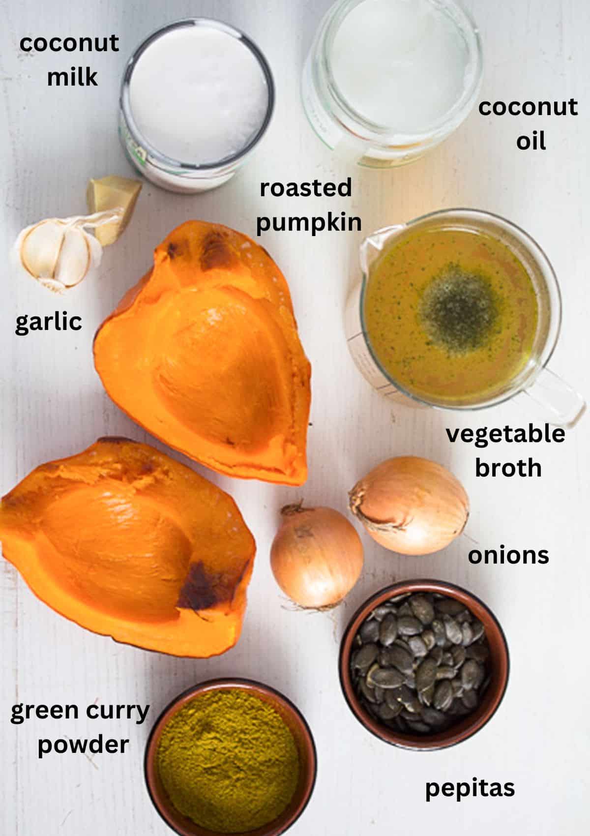 listed ingredients for making pumpkin soup with coconut milk and oil, onions, garlic, curry, stock, and pepitas.