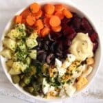 salade russe with potatoes, carrots, beets, eggs and mustard in a bowl.