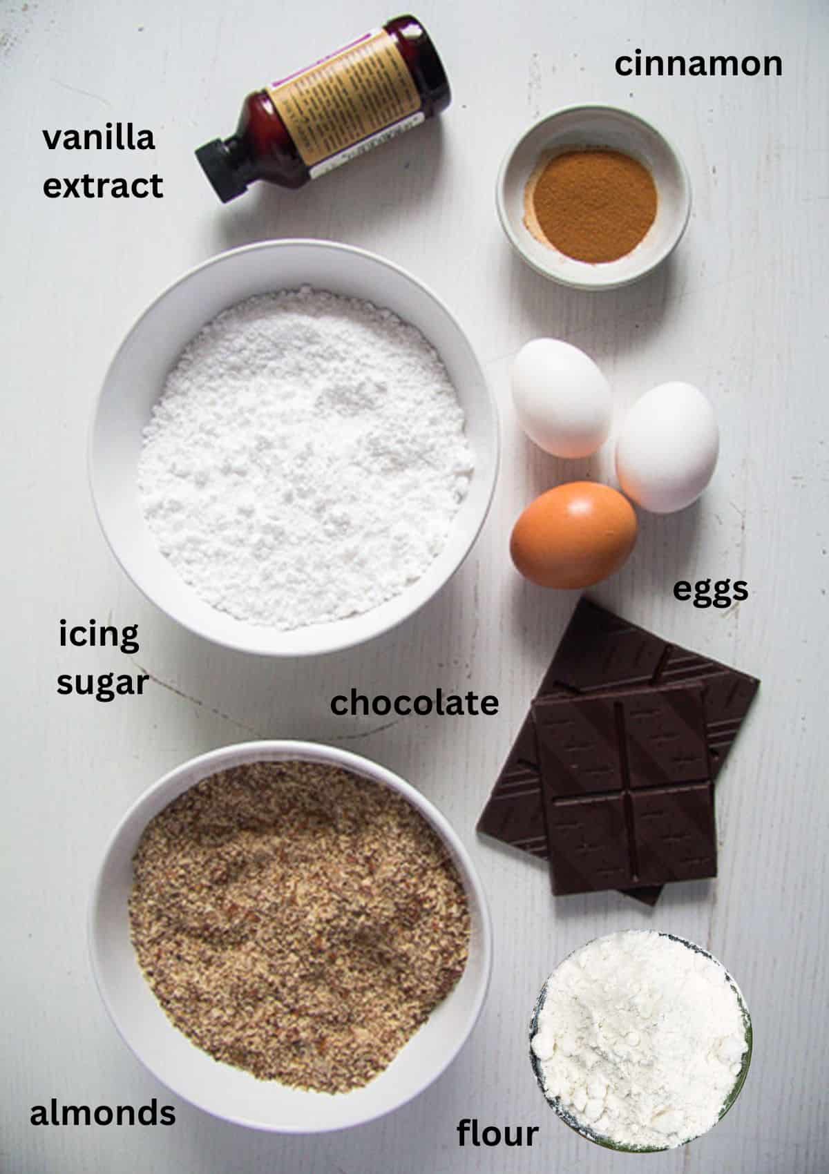 listed ingredients for making cookies with chocolate, almonds and icing sugar.