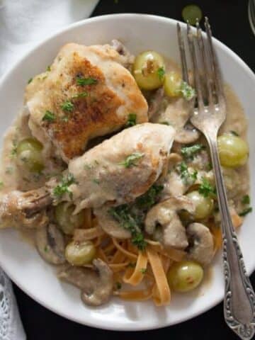 coq au riesling with mushroom and grapes served over pasta.