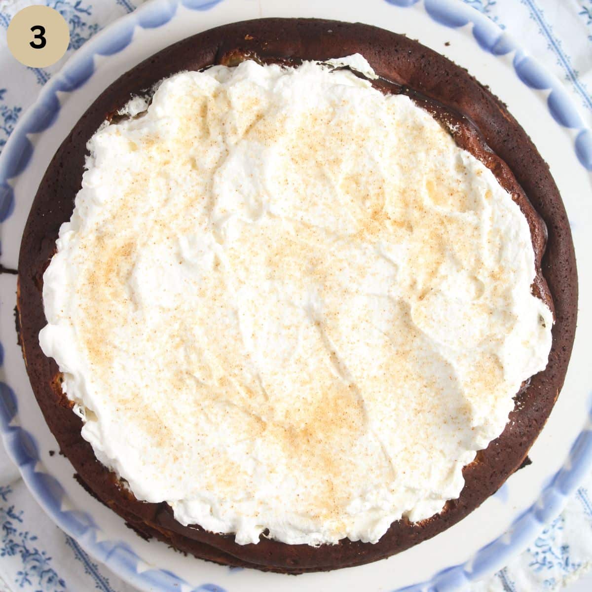 overhead view of cake topped with cream and brown sugar.