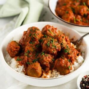 curried turkey meatballs heaped on a bed of rice in a bowl.