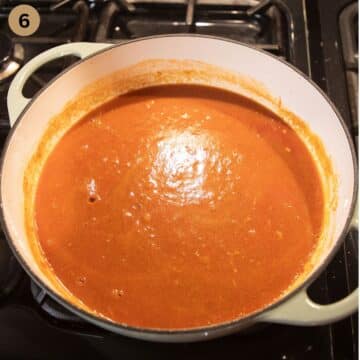 adding passata and spices to a pot to make turkey meatball curry.