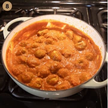 turkey meatballs simmering in curry sauce in a large pot.