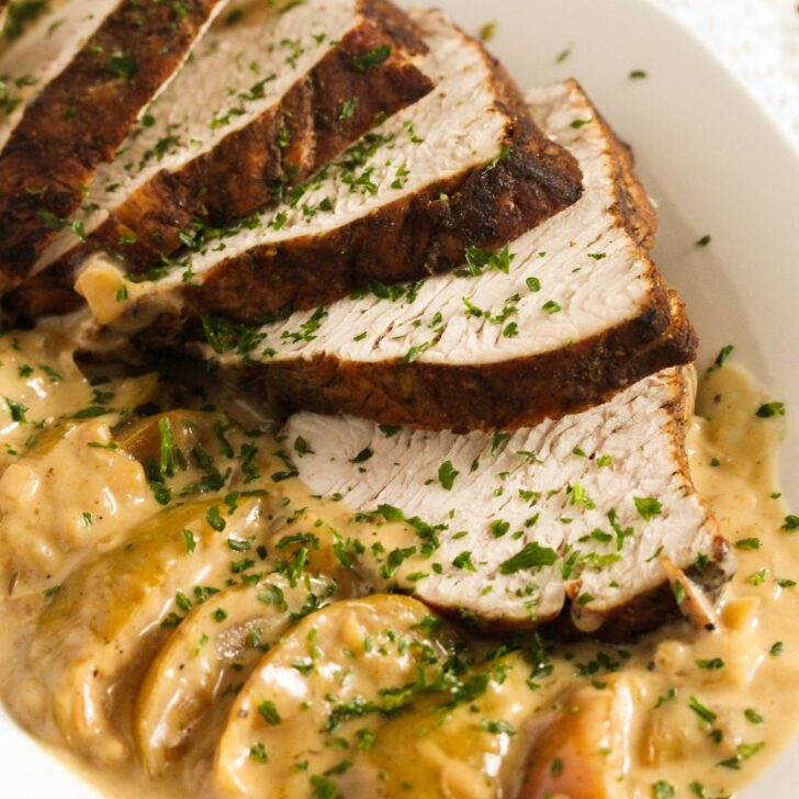 dutch oven turkey breast sliced with apples and cream sauce.