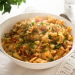 fried cabbage with bacon in a small white bowl.